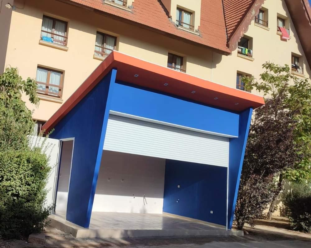Kiosque Isoboard avec façade bleue et rideau métallique