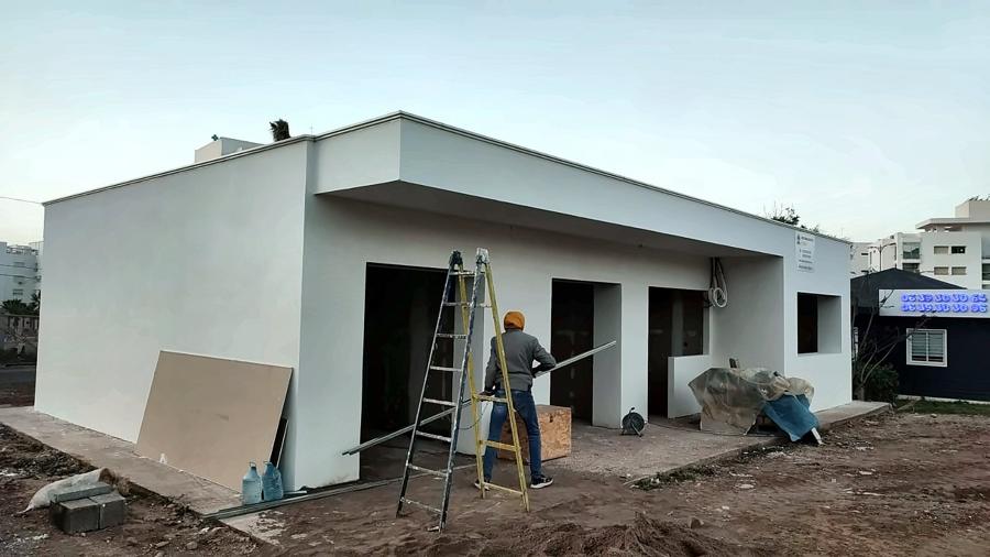 Bâtiment commercial enduit en blanc, finitions en cours