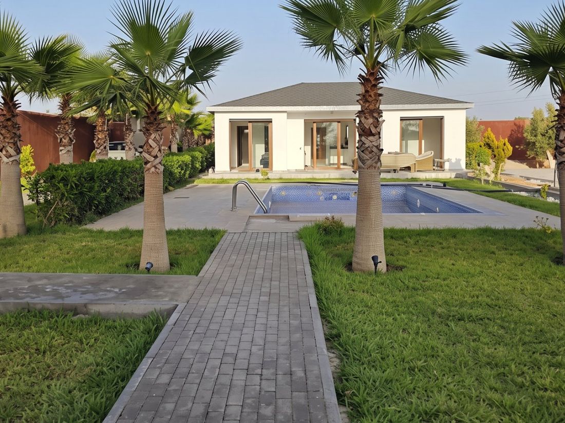 Villa de plain-pied en construction légère avec piscine et jardin de palmiers